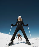 Two skiers on a snowy mountain with a clear blue sky